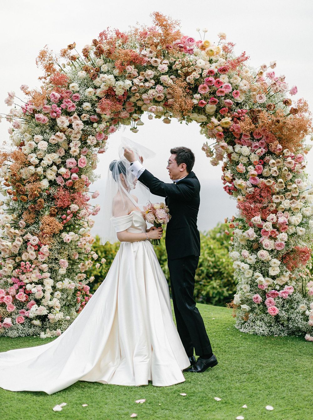Wedding ceremony arch adorned with flowers and greenery, creating a picturesque setting for a Phuket, Thailand wedding.