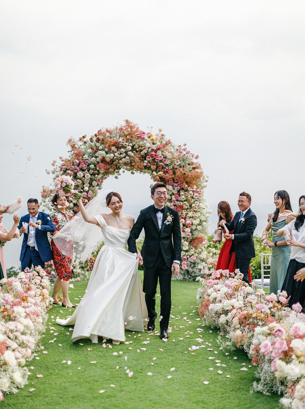 Newlyweds leaving a wedding ceremony in Phuket, Thailand, photographed by a wedding photographer.