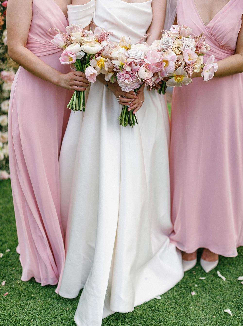 Bride and bridesmaids in pink dresses holding bouquets at a wedding in Phuket, Thailand.