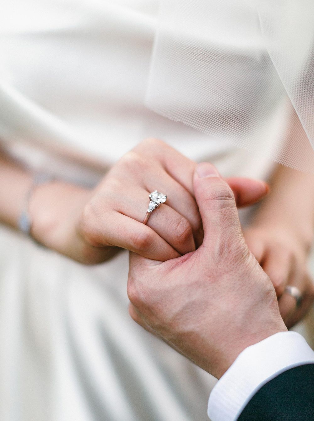 Bride and groom holding hands with a ring, close up shot in Phuket, Thailand.