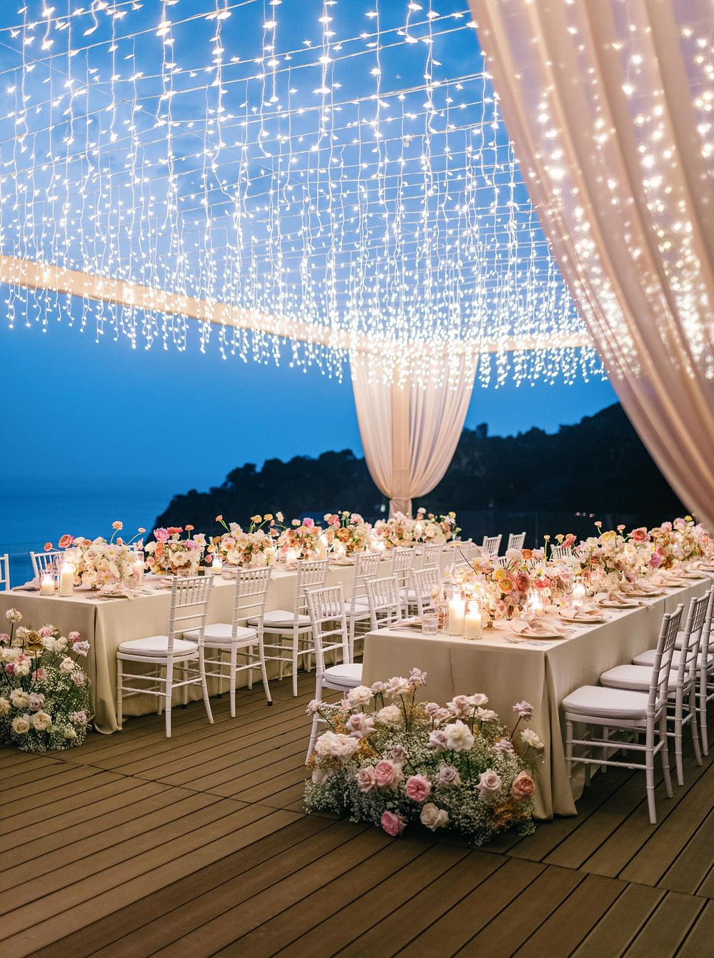 Outdoor wedding reception with white lights and ocean view at a romantic wedding in Phuket, Thailand.