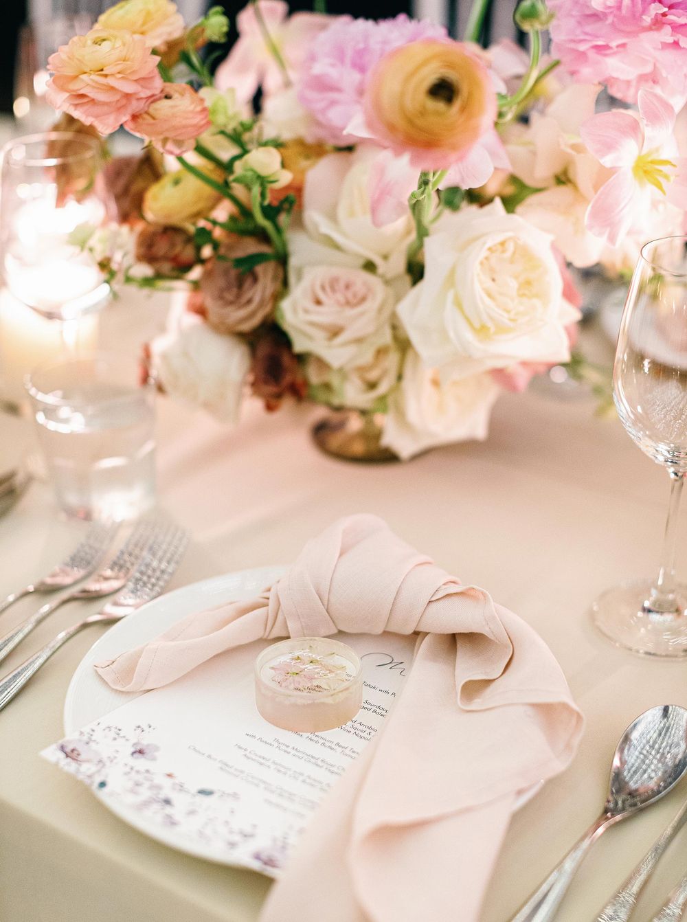 A table setting at a wedding reception in Phuket, Thailand, featuring pink napkins and silverware.