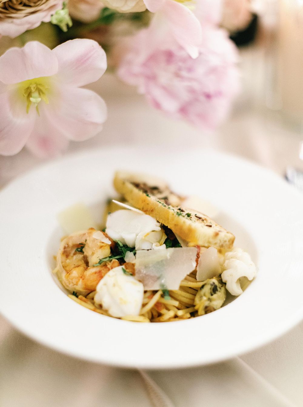 A plate of shrimp and cheese pasta on a table, wedding reception food in Phuket, Thailand.