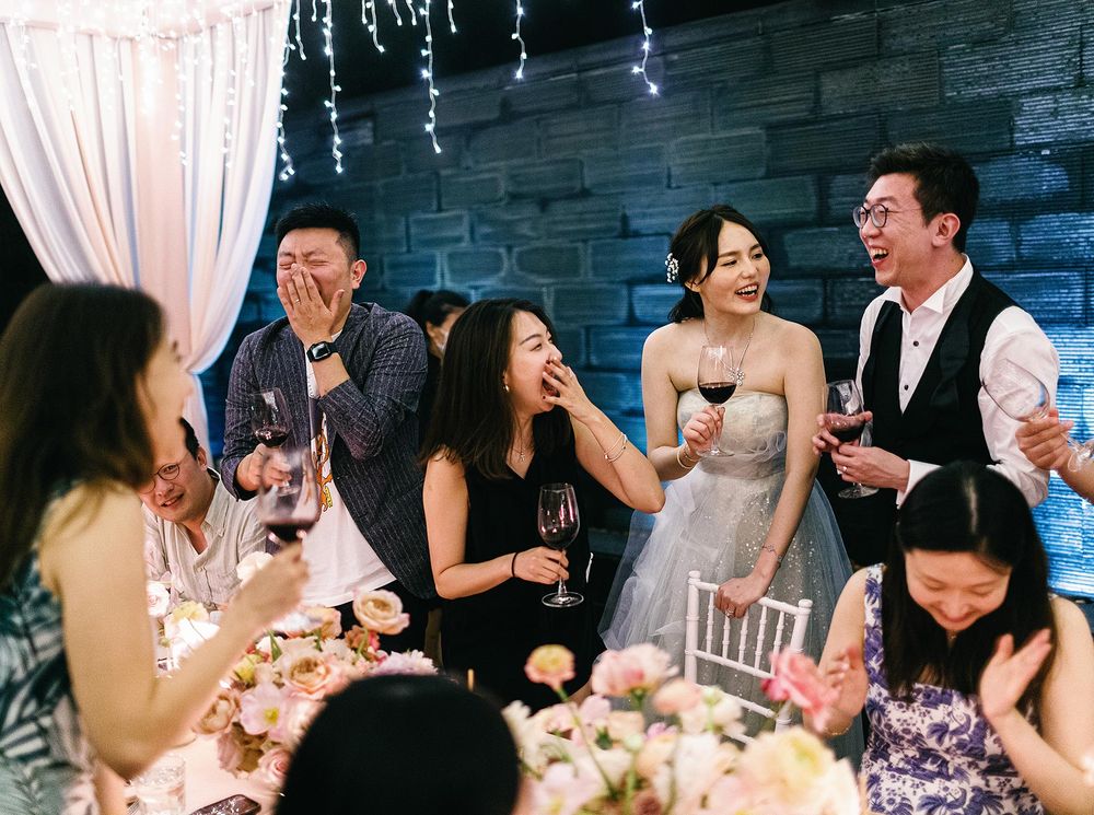 A joyful wedding reception in Phuket, Thailand, featuring a group of people celebrating the special occasion together.