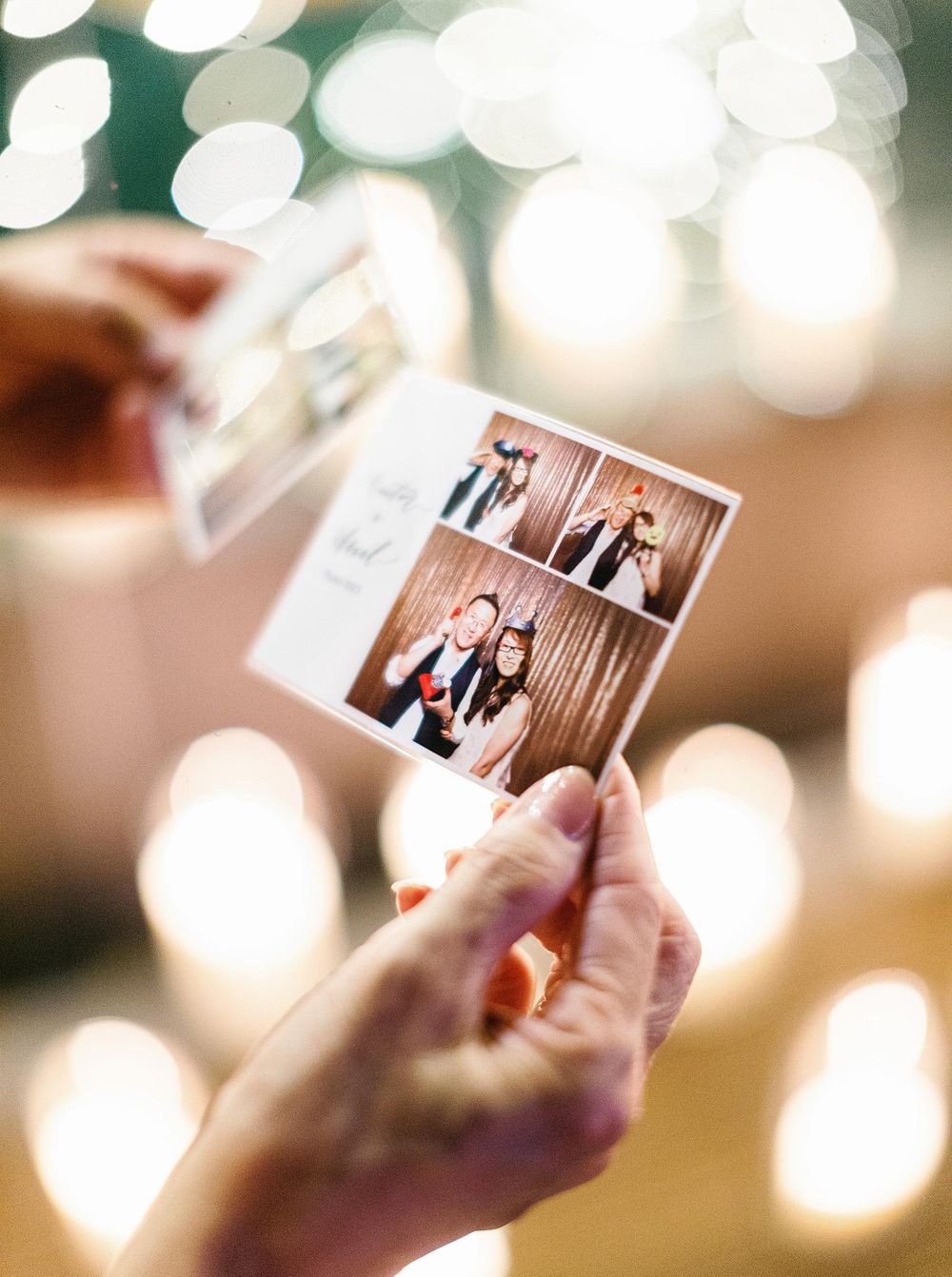 A person proudly displays a photo of a wedding at a reception in Phuket, Thailand.