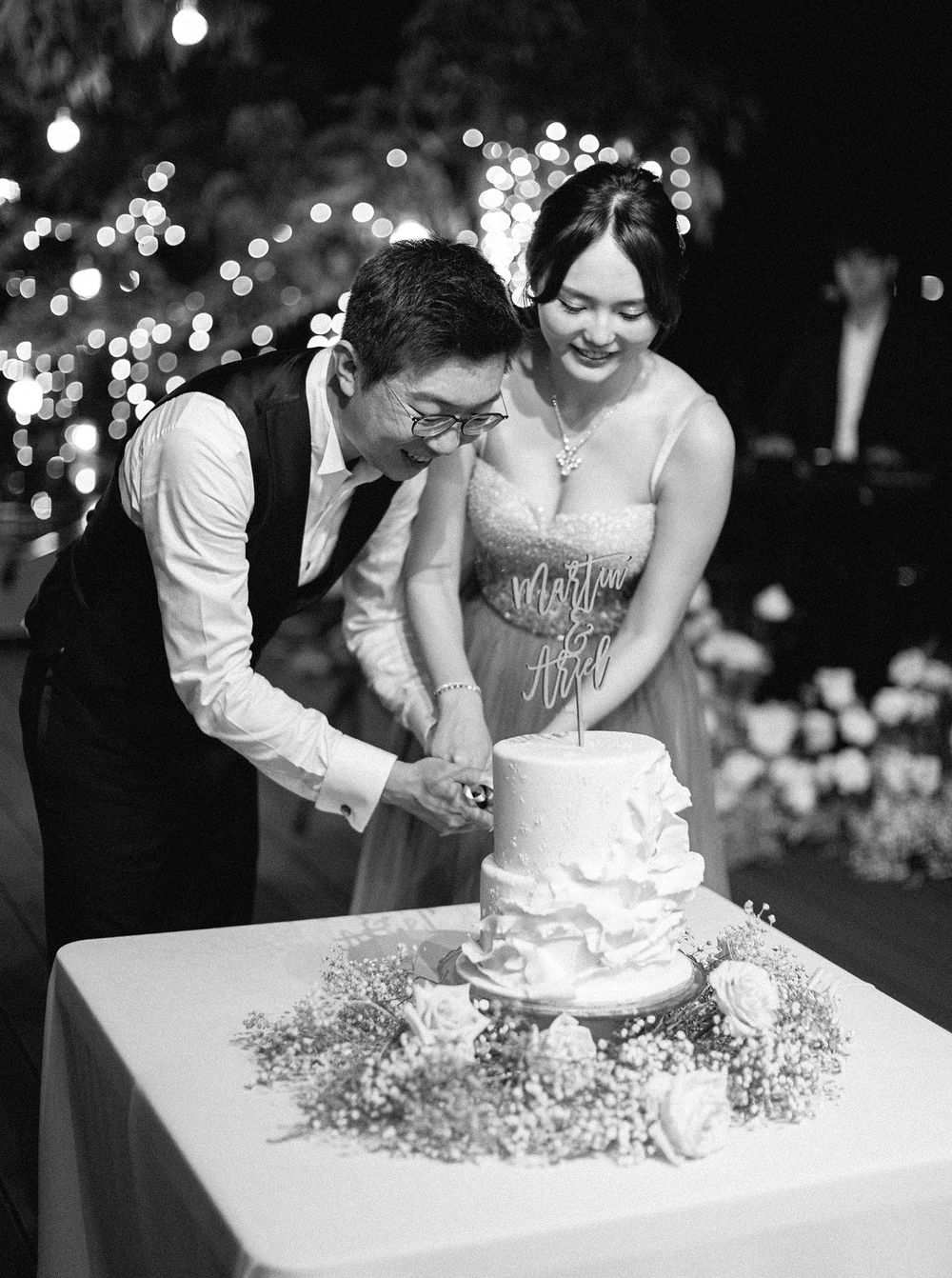 A joyful couple in Phuket, Thailand sharing a special moment as they cut into their wedding cake.