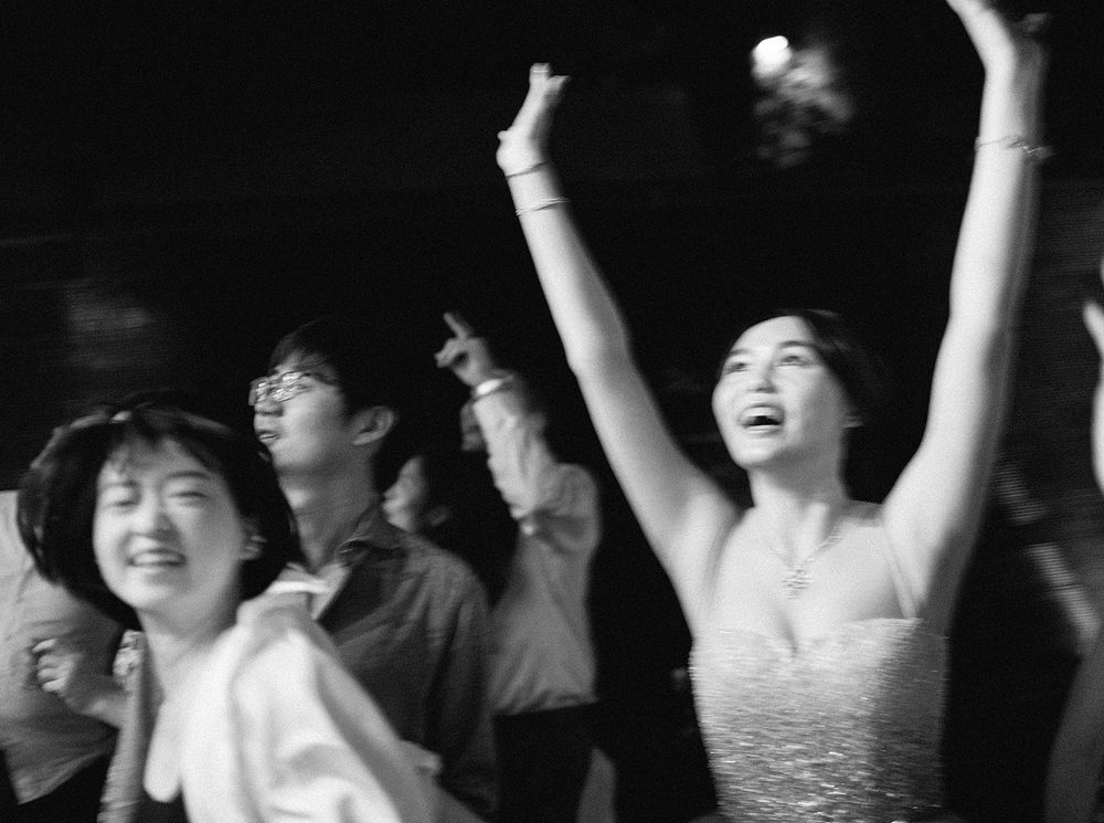 A lively wedding party in Phuket, Thailand, with a group of people joyfully dancing and celebrating together.