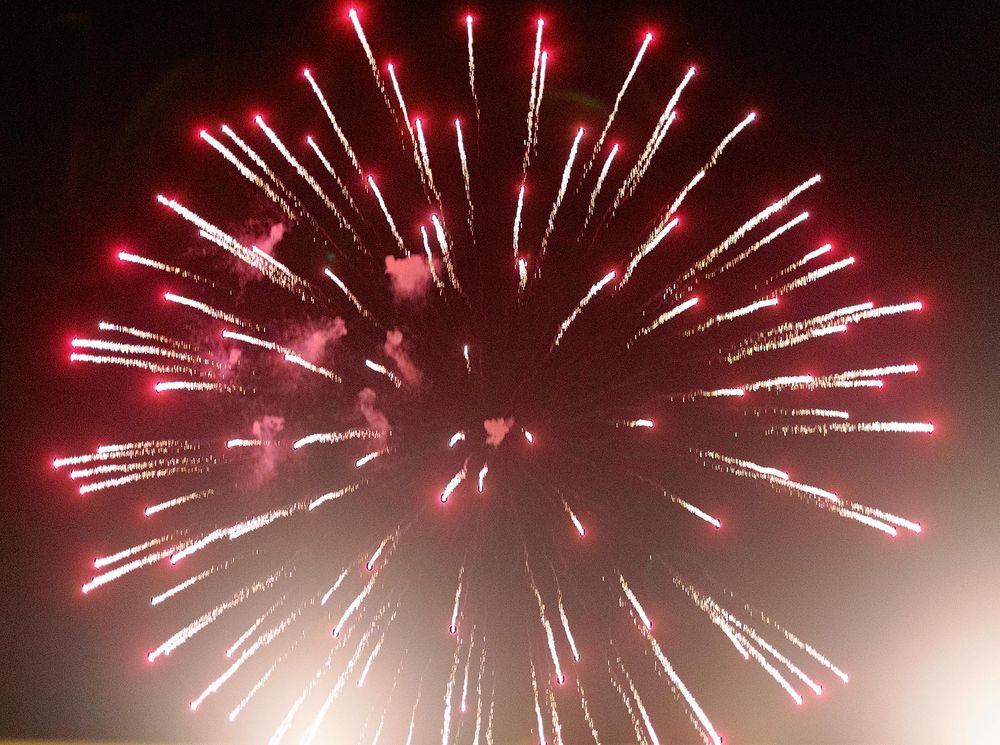 A vibrant red and white firework illuminates the sky during a dazzling display in Phuket, Thailand.