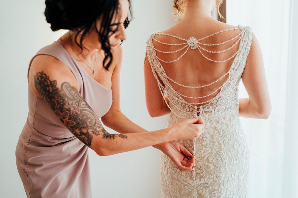 Detailed view of an intricate beaded back design on a white wedding gown.