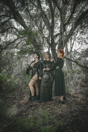 Atmospheric forest photoshoot featuring gothic fashion and moody lighting.