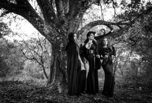 Multiple panels showing figures in black clothing posing dramatically under a large tree in a wooded setting.