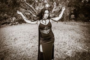 Artistic portrait sequence showing movement and flowing black fabric in a natural outdoor setting.