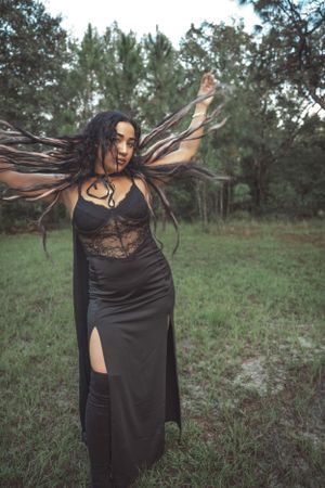 Dramatic fashion series featuring flowing black dress and lace details against a wooded backdrop.