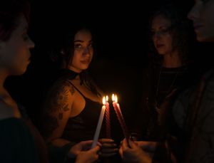People holding candles in darkness during an evening ceremony.