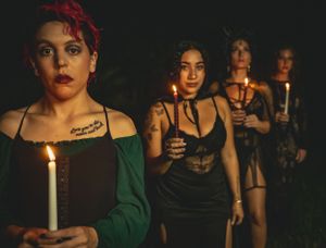 Candlelit faces illuminated in darkness during a night ceremony.