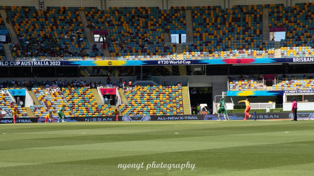 Rainbow mosaic pattern decorates stadium seating section during sporting event.