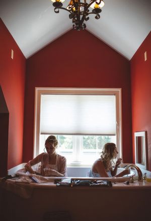 Bridesmaids sit in bathtub while getting ready for wedding in Salida, Colorado.