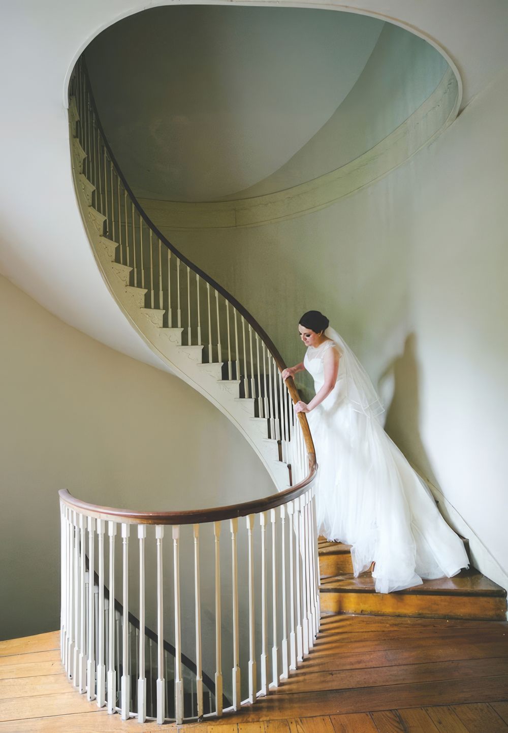Alex is wearing her wedding dress while standing in the stairway in Lexington, Kentucky.