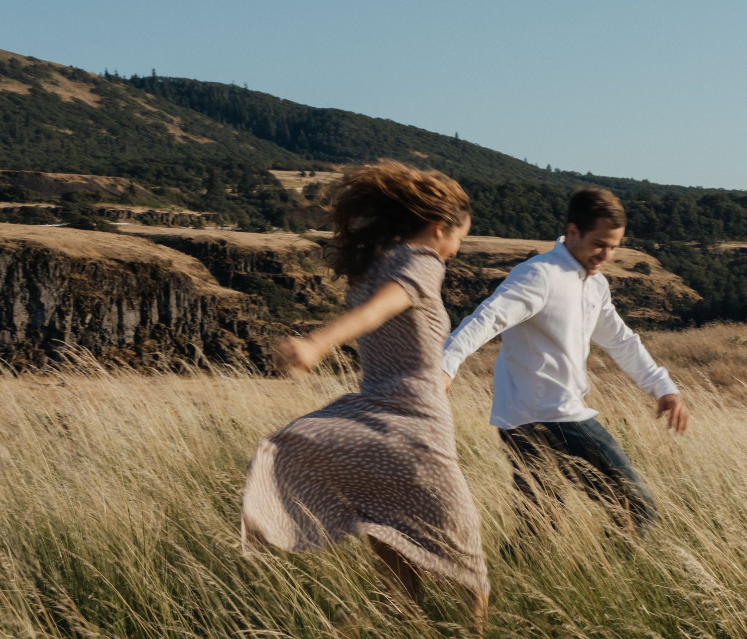 Color shot of couple running through wheat field