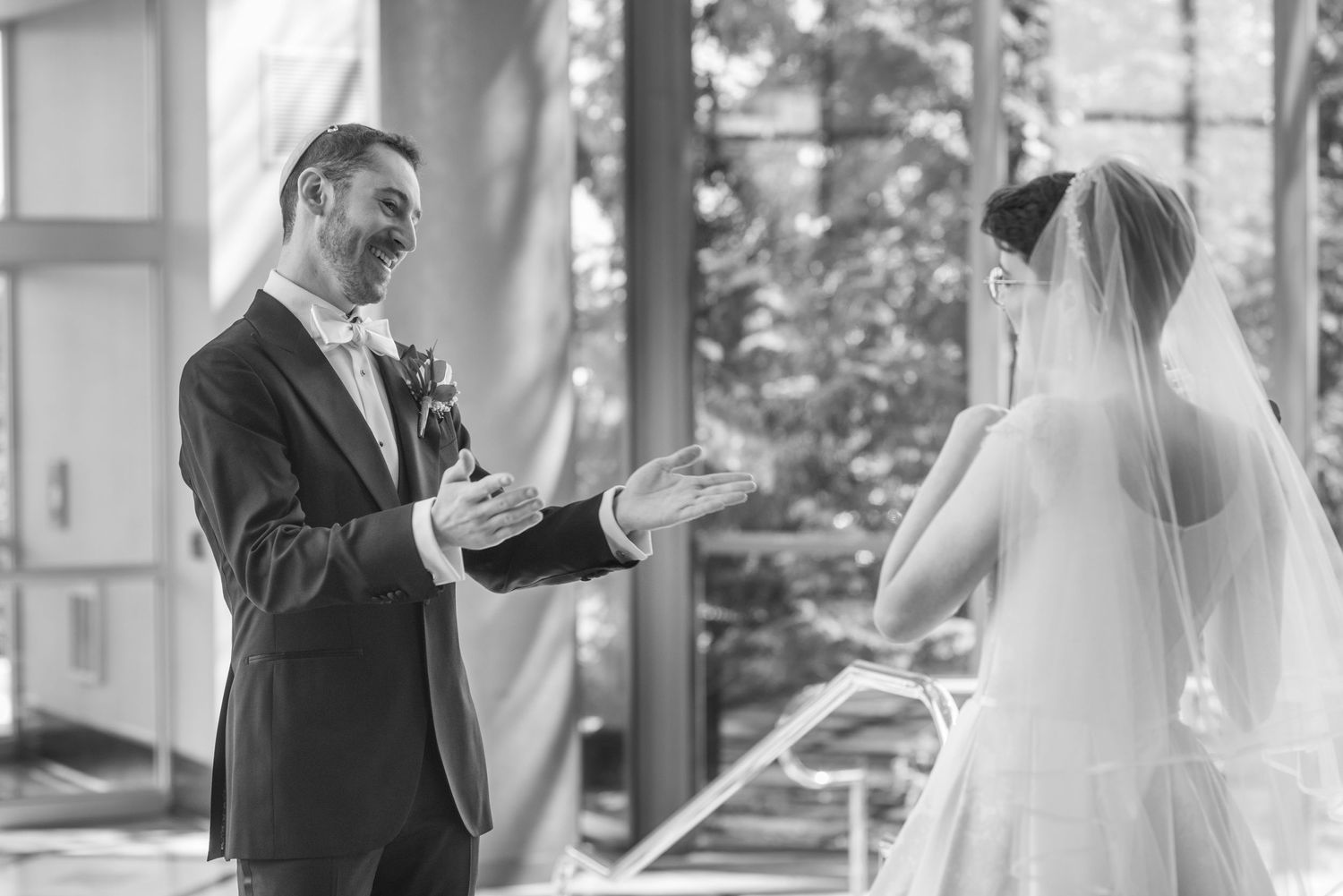Black and white photo of first look reaction between couple at a wedding.