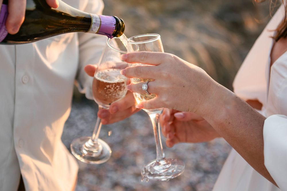 Hands toasting with champagne glasses during a celebration.