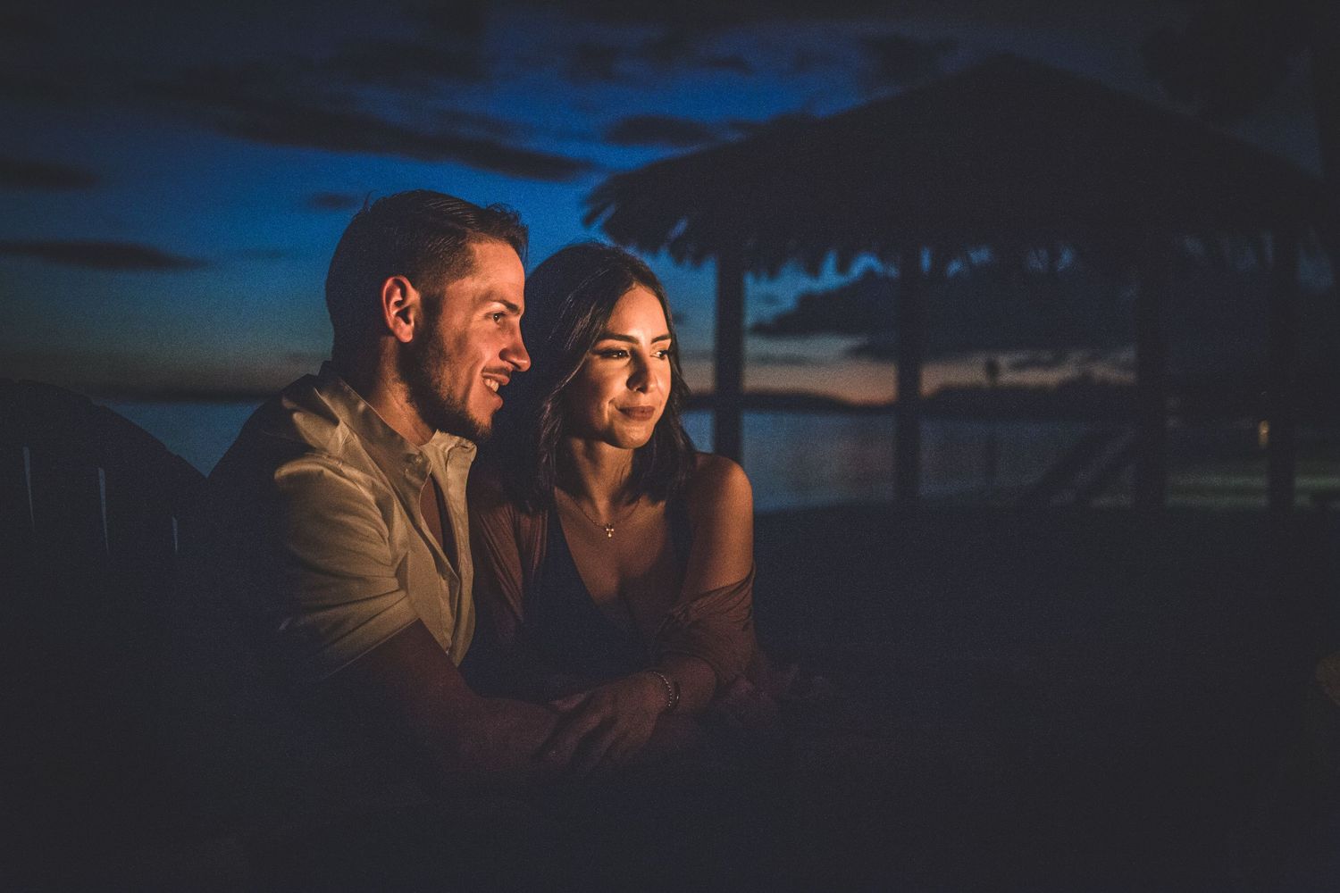 Romantic evening photo of couple illuminated by soft blue light at sunset.