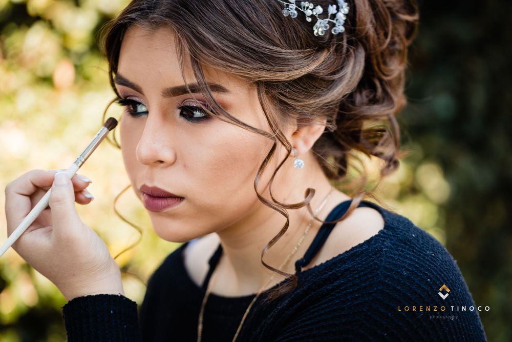 A makeup artist applies cosmetics during a beauty preparation session outdoors.