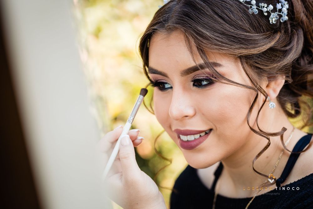 A makeup artist puts finishing touches on elegant evening makeup.