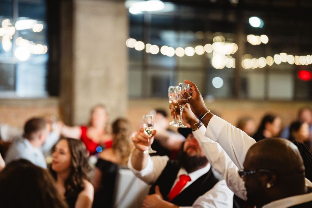 Wedding guests raise their glasses in a celebratory toast during the reception.