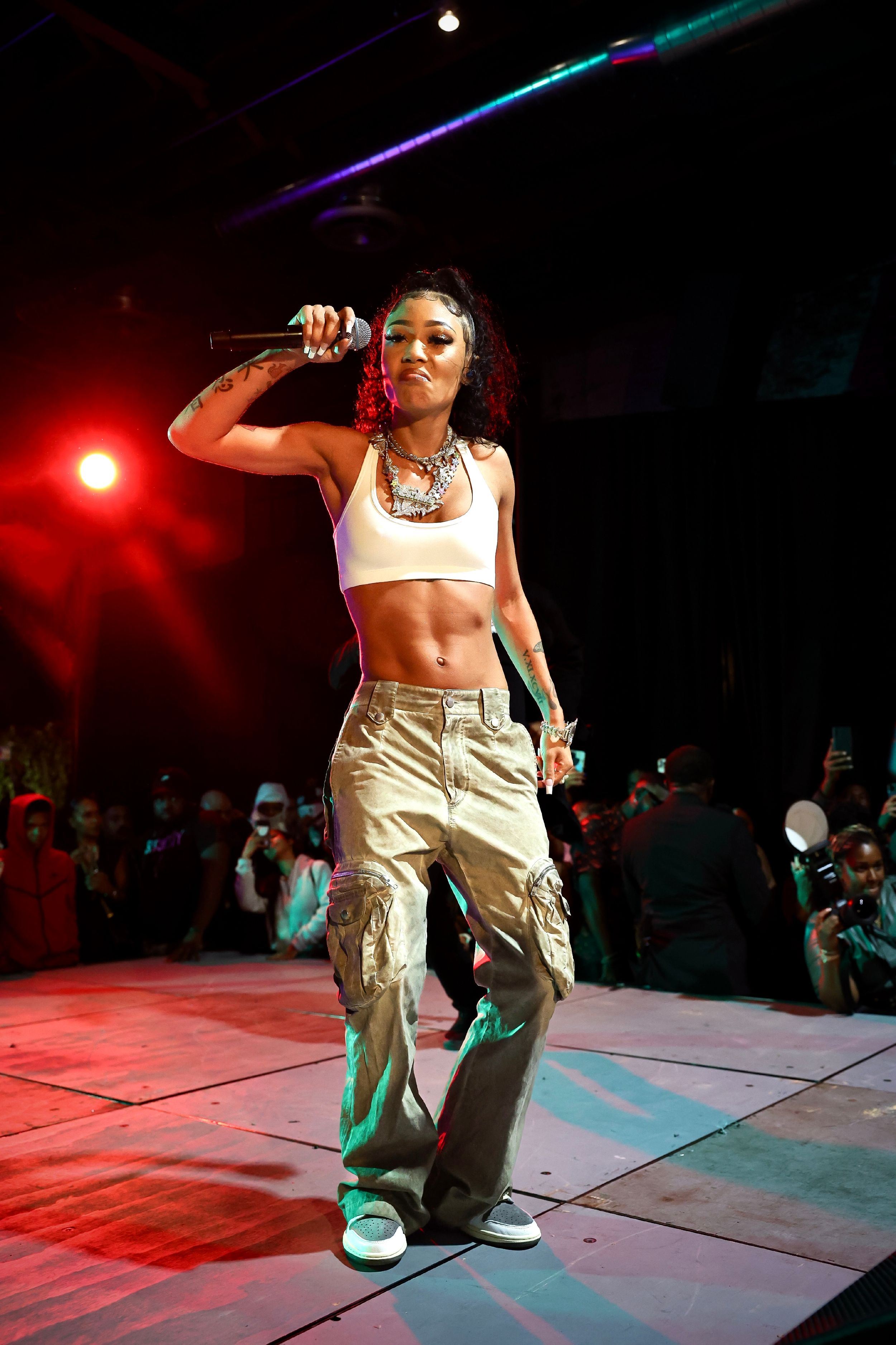 Dynamic concert performance with performer in athletic wear on red-lit stage.
