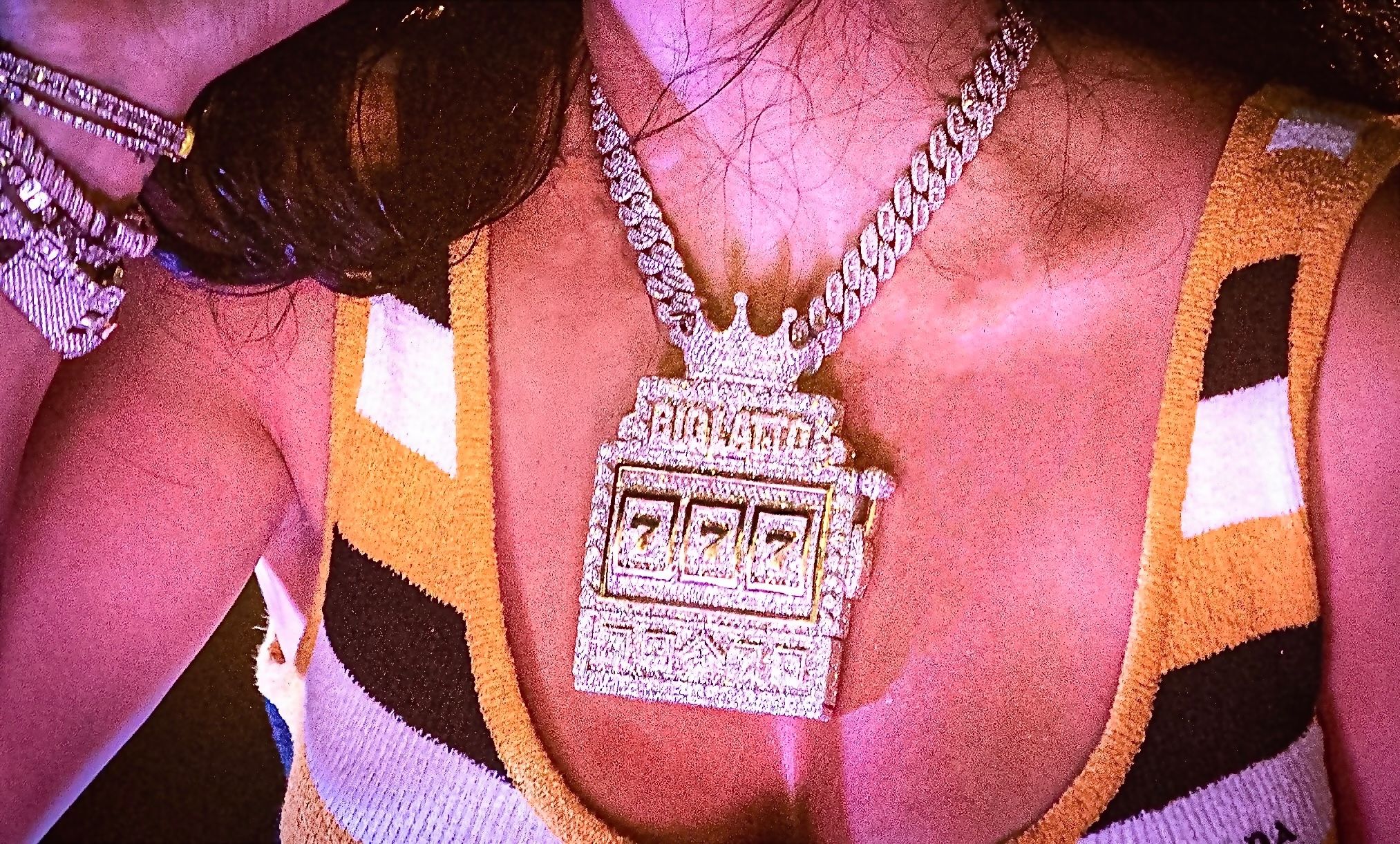 Close-up of bejeweled slot machine pendant necklace on chain.