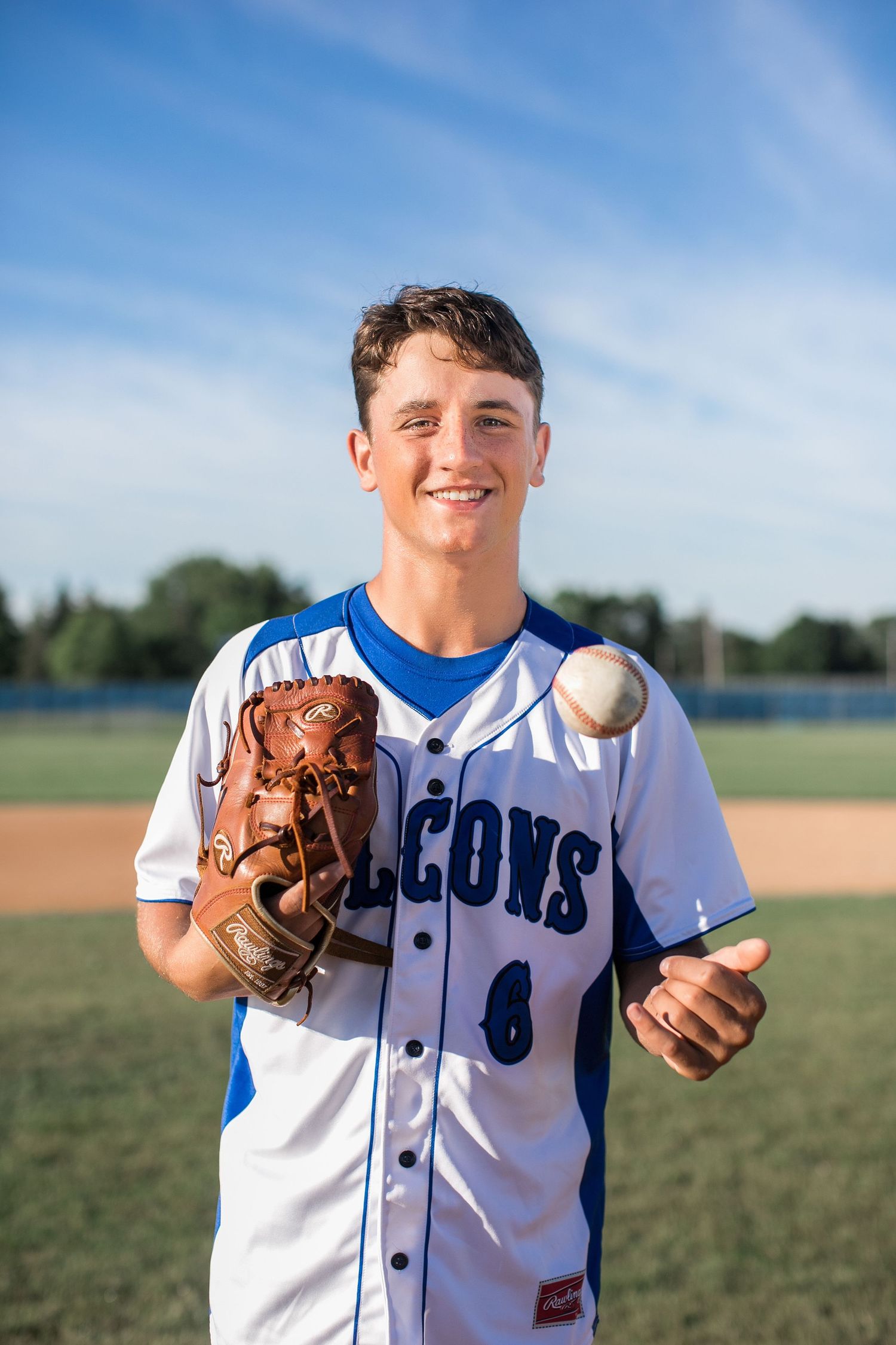 High school senior baseball player with glove and ball during senior pictures. Foley, Minnesota