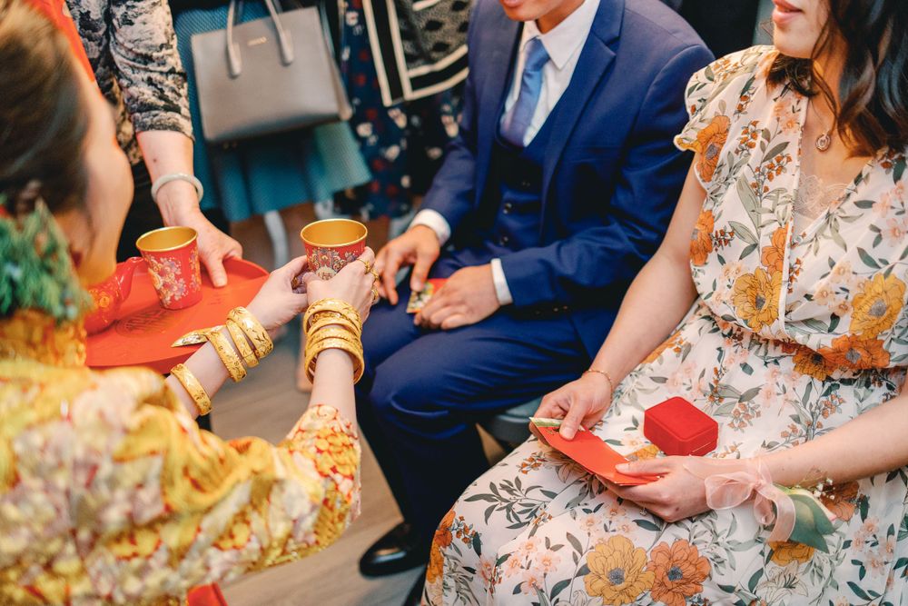 Wedding guests exchange red envelopes and gifts during a traditional ceremony celebration.