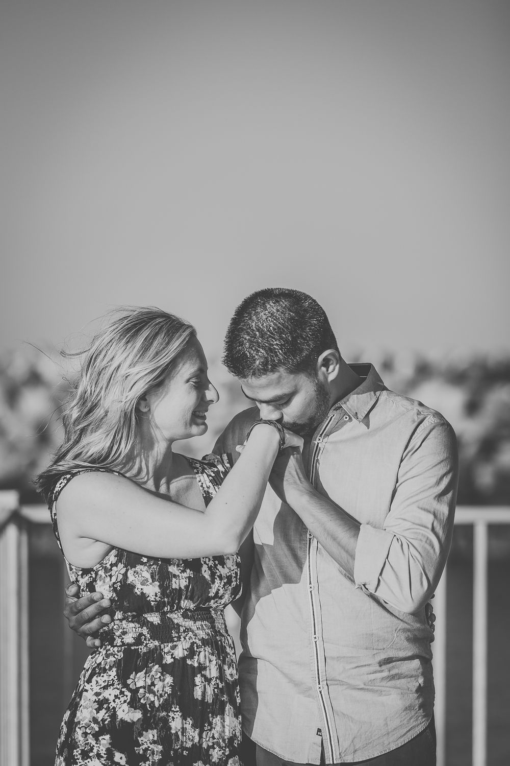 Black and white image of a couple sharing an intimate moment outdoors.