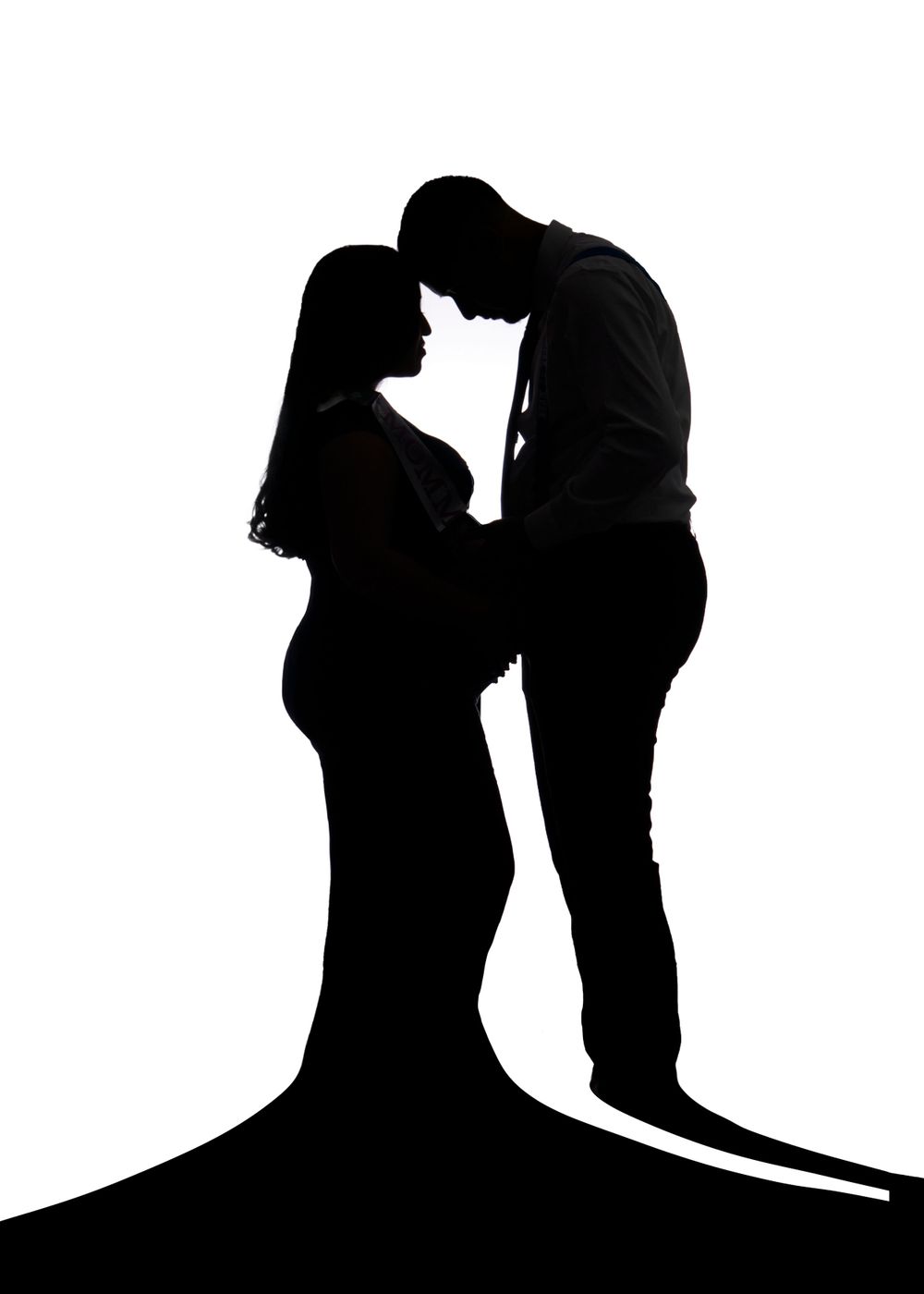 Artistic black and white silhouette of expecting couple in embrace.