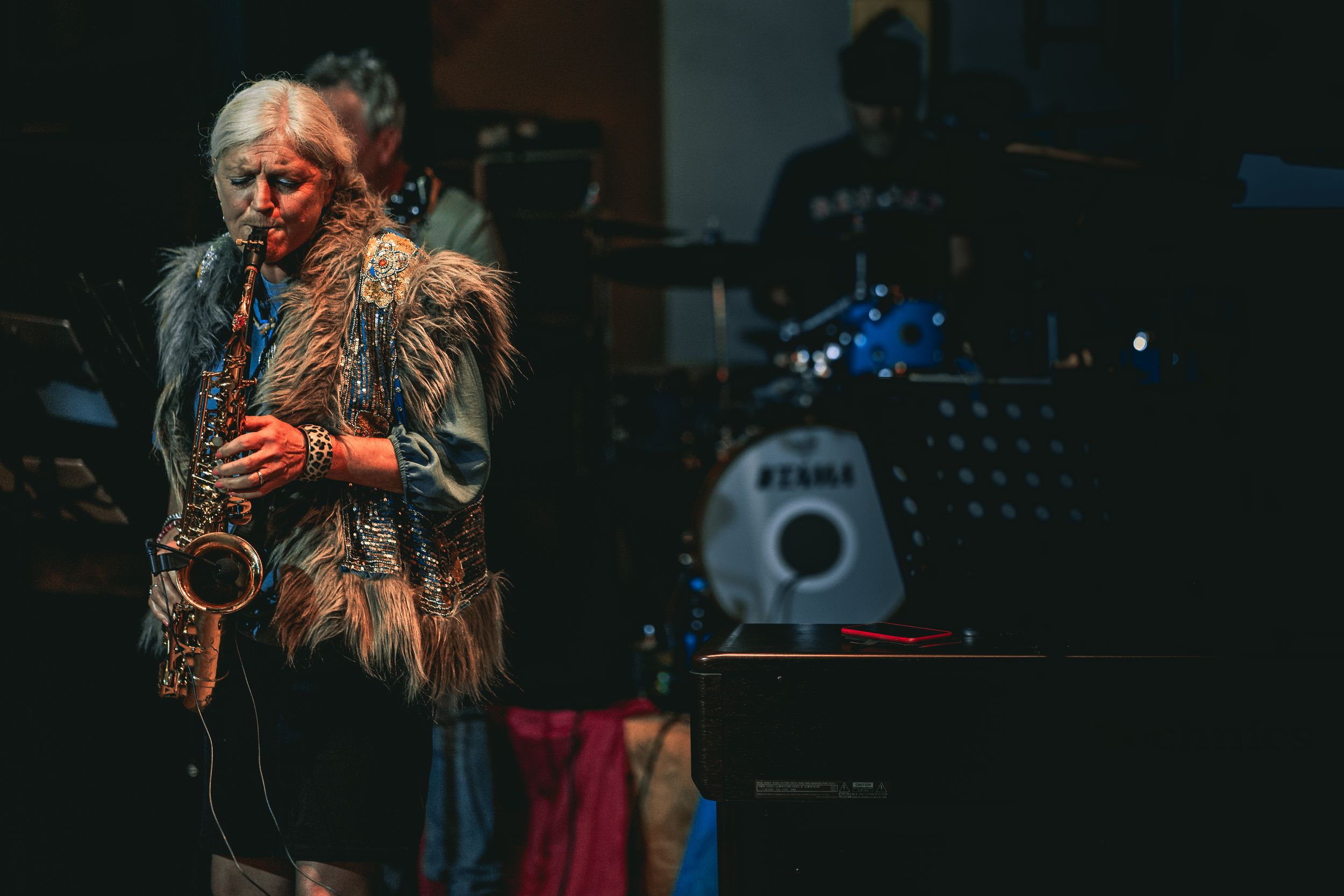 Live music performance in a dark venue with moody atmospheric lighting.