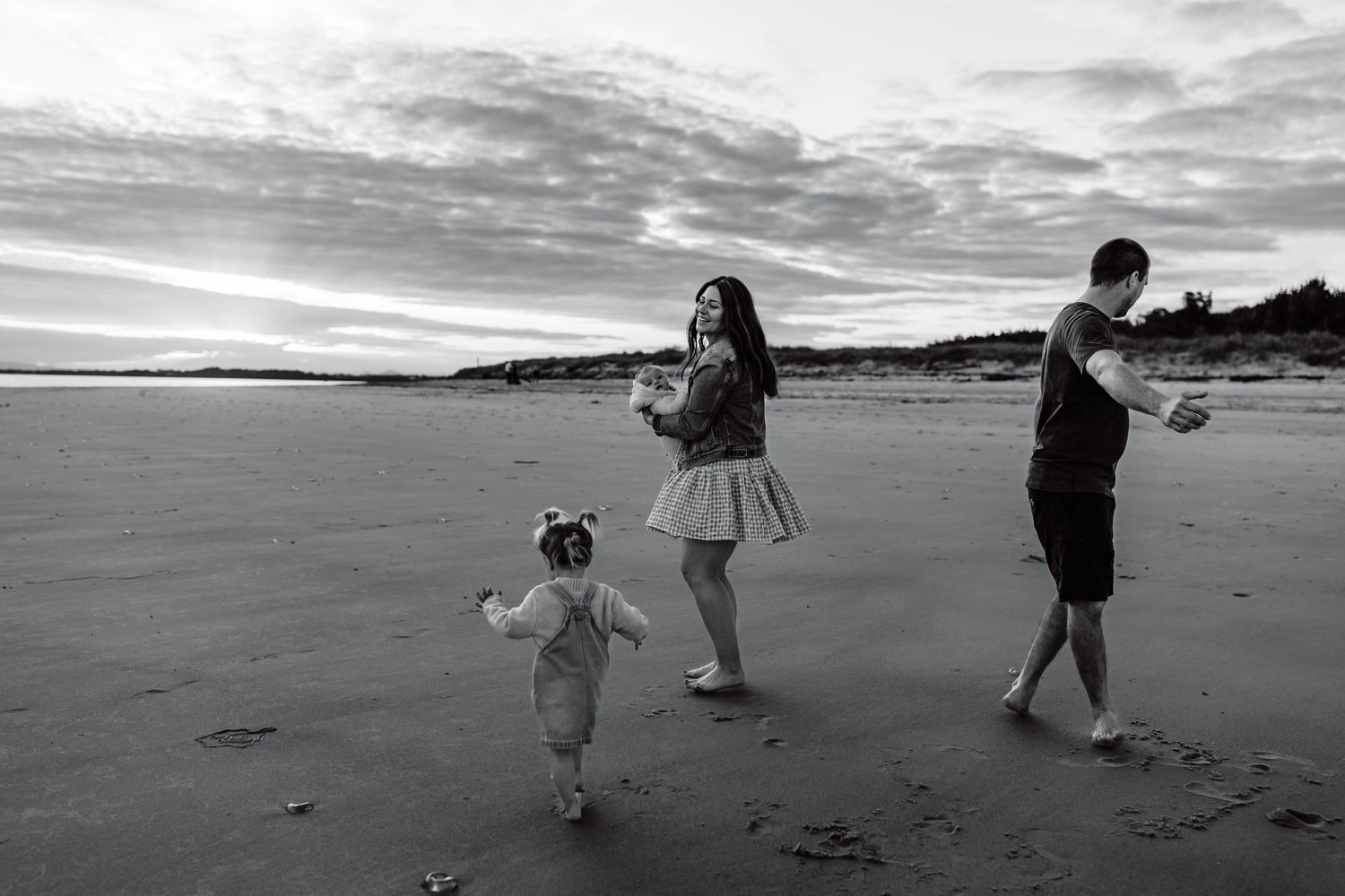 black and white image of family dancing at the beach on Bribie Island