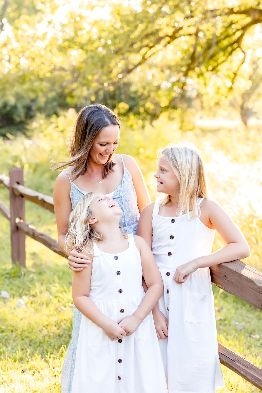 Candid moments of joy captured between family members in white dresses during sunset shoot.
