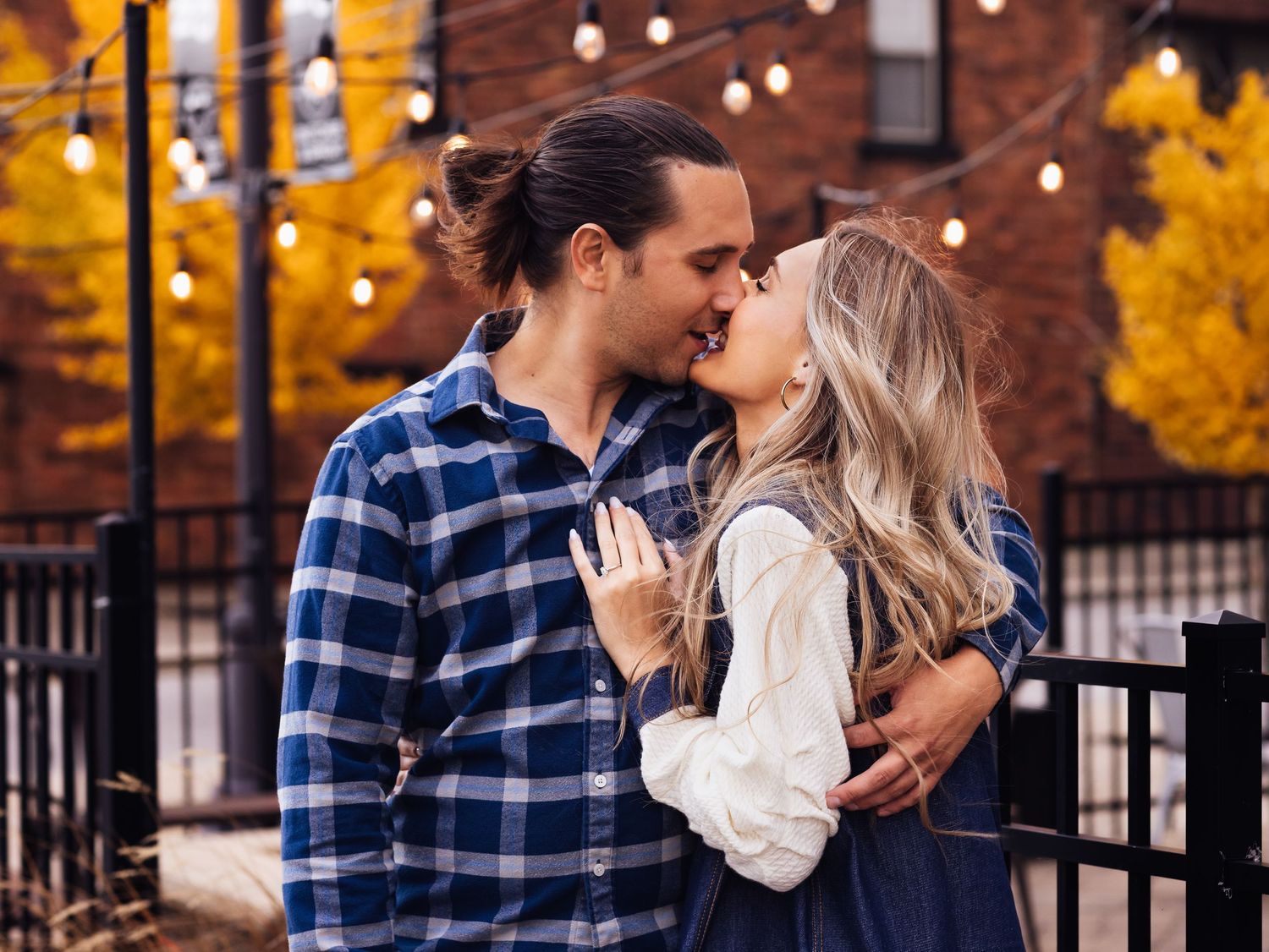 engagement photo session of couple kissing under city lights