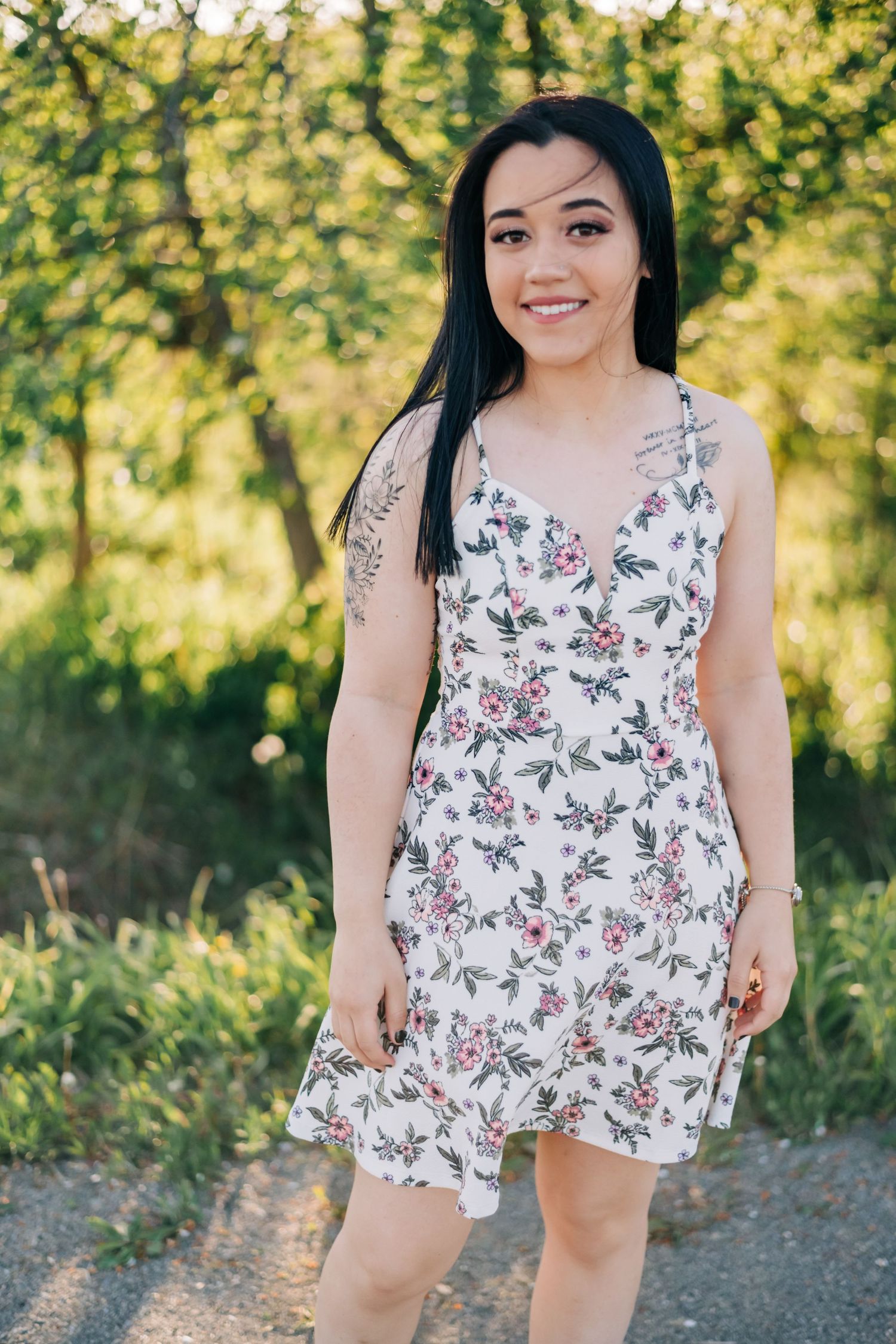 high school senior wearing a white dress standing on a dirt road