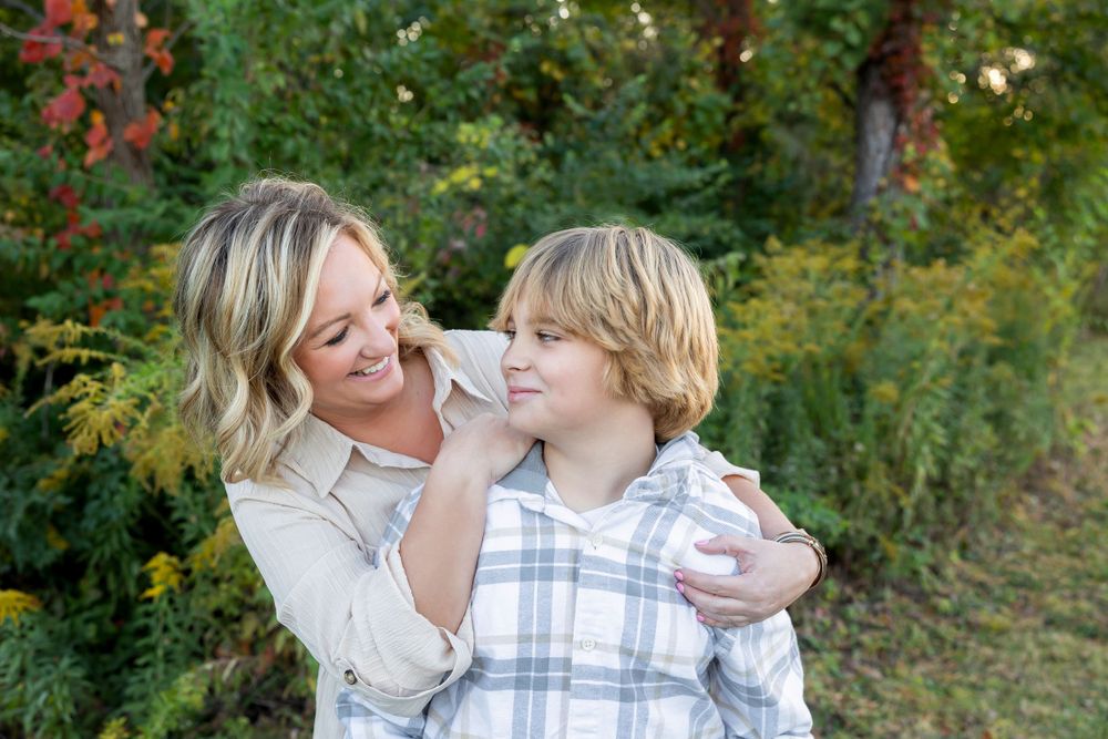 Tender moment captured between two people against natural outdoor backdrop.