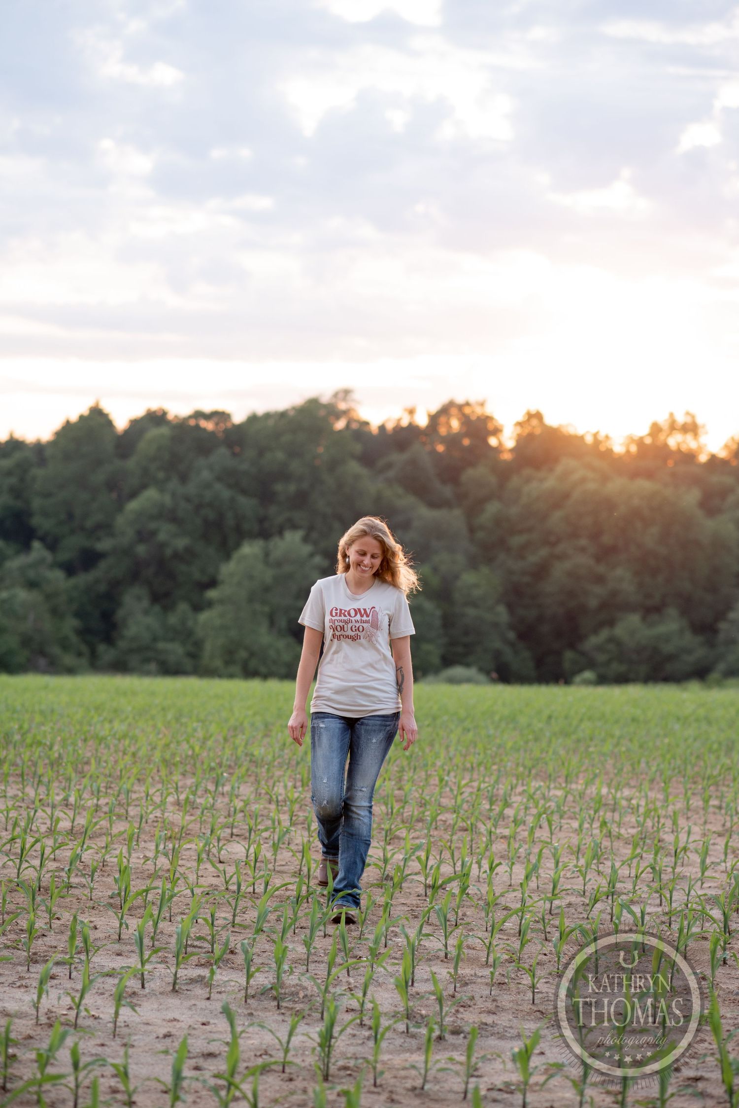 Walking through a young corn field at sunset with trees silhouetted in background.