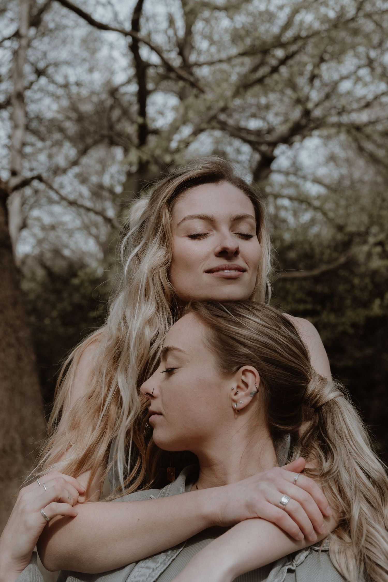 Two people sharing an intimate embrace outdoors with soft, warm lighting.