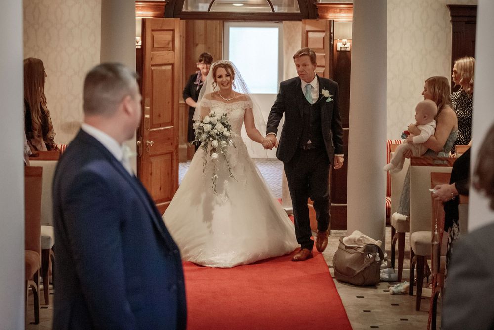 groom turns to watch his bride walking up the aisle with her father