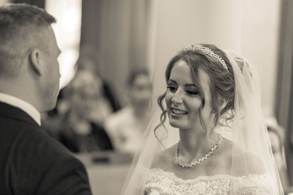 bride and groom smiling at each other during the wedding ceremony