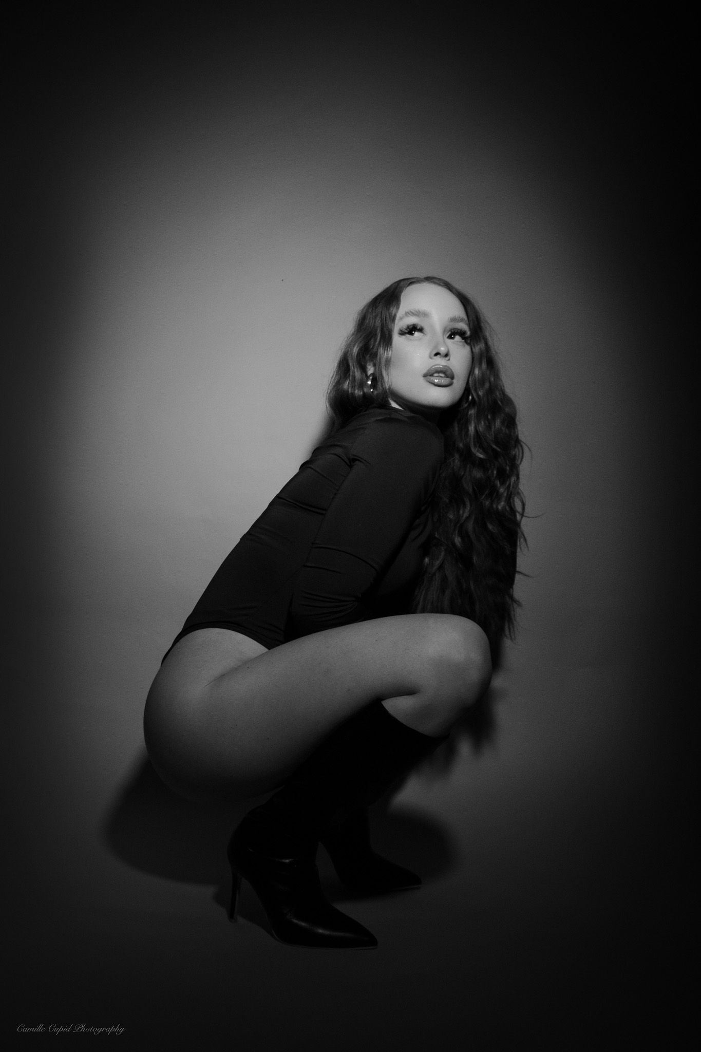 Elegant black and white photography capturing the beauty of a Fashion Nova bodysuit on a female model.