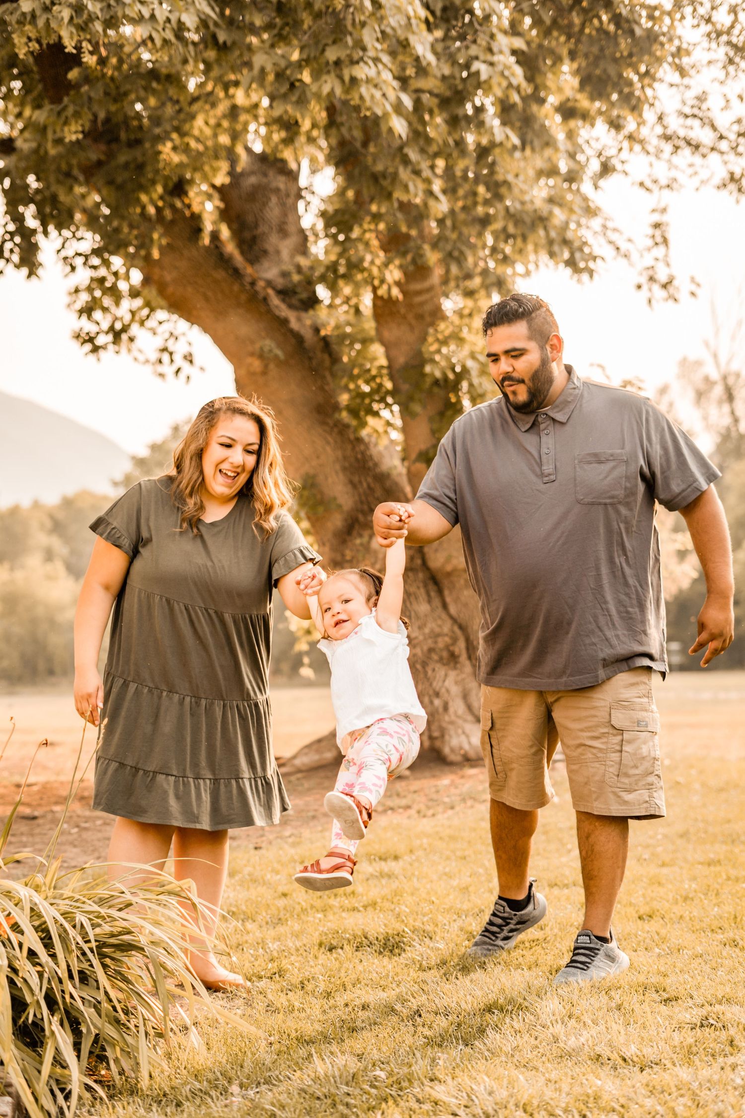 Family enjoying playful moment together outdoors during golden hour.