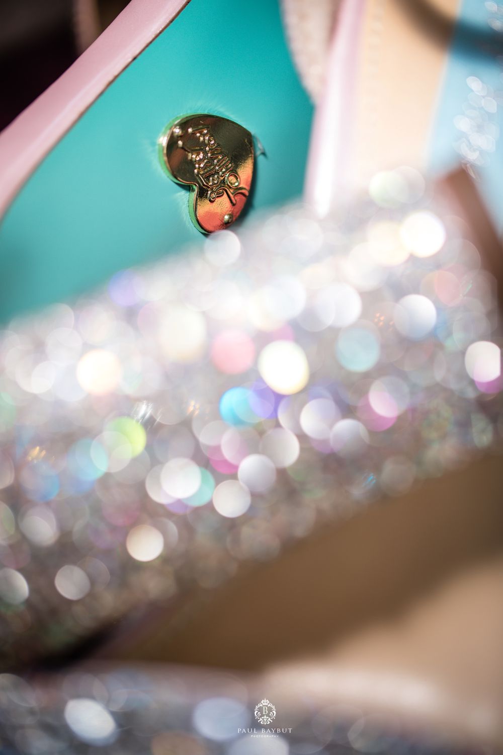 Abstract macro shot of a reflective surface with glittering bokeh lights in turquoise and pink.