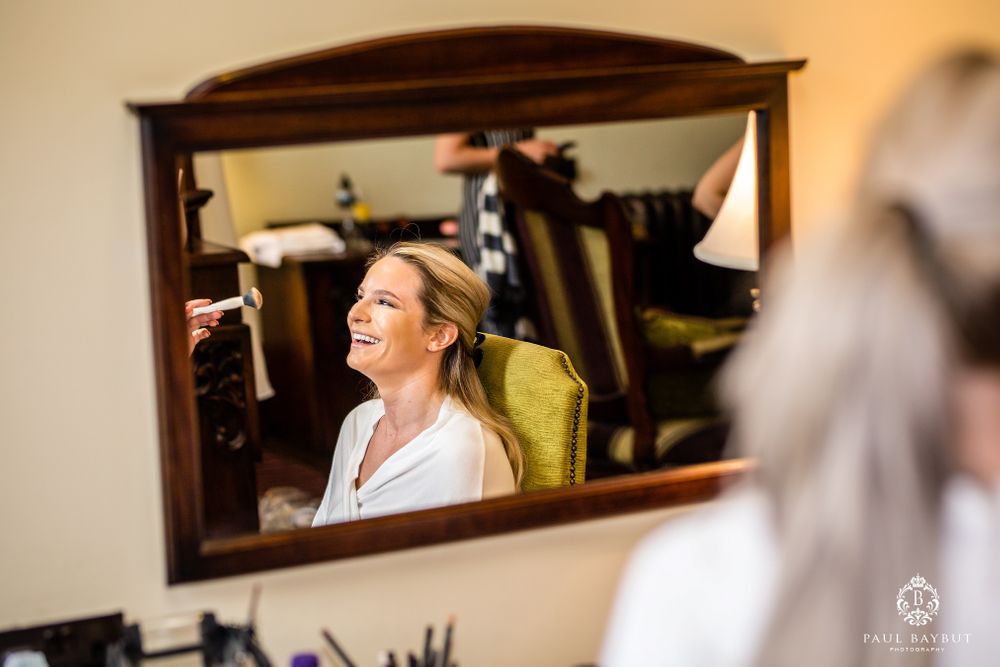 Mirror reflection captures candid moment during wedding preparation.