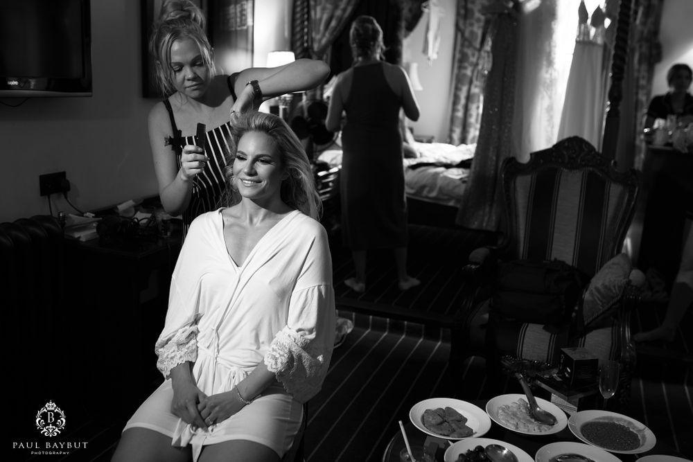 Wedding preparations in progress with stylists working in an elegant room.
